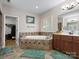Bright bathroom featuring a soaking tub with tile surround, double vanity, and walk-in closet at 416 Zelkova St, York, SC 29745