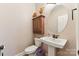 Clean bathroom with a pedestal sink, toilet, and a wooden wall cabinet at 416 Zelkova St, York, SC 29745