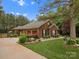 Brick home featuring a manicured lawn, landscaping, and attached garage at 416 Zelkova St, York, SC 29745