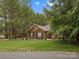 Charming single-story brick home with well-manicured lawn, mature trees, and blooming flowers at 416 Zelkova St, York, SC 29745