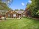 Charming single-story brick home with well-manicured lawn, mature trees, and blooming flowers at 416 Zelkova St, York, SC 29745