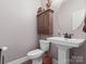 A cozy powder room with a pedestal sink, cabinet, and neutral tones offers a convenient space at 416 Zelkova St, York, SC 29745