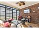 Relaxing sunroom boasts brick wall, comfy seating, and large windows at 416 Zelkova St, York, SC 29745