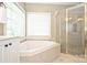 Bathroom with corner bathtub and glass shower at 6726 Thornton Oaks Ct, Charlotte, NC 28270