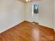 Bright bedroom with wood-look floors and large window at 8003 Regent Park Ln, Charlotte, NC 28210