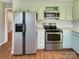 Bright kitchen features stainless steel appliances and light green cabinets at 8003 Regent Park Ln, Charlotte, NC 28210
