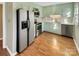 Kitchen with light green cabinets, stainless steel appliances, and wood flooring at 8003 Regent Park Ln, Charlotte, NC 28210