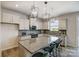 Modern kitchen with granite countertops, white cabinets, and island with seating at 8012 Downy Oak Ln, Charlotte, NC 28269