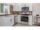 Modern kitchen with white cabinets, stainless steel appliances, and quartz countertops at 8260 Blades Trl, Denver, NC 28037