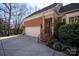 View of a two-car garage with brick exterior and steps leading to the entrance at 8520 Greencastle Dr, Charlotte, NC 28210