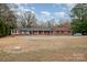 Brick ranch house with a long driveway and landscaping at 9330 Bellhaven Blvd, Charlotte, NC 28214