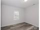 Simple bedroom with hardwood floors and a window with blinds at 13331 Central Ave, Huntersville, NC 28078