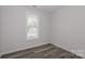 Bright bedroom with wood-look floors and large window at 13331 Central Ave, Huntersville, NC 28078