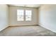 Bright bedroom with neutral carpeting and two large windows at 14922 Tamarack Dr, Charlotte, NC 28278