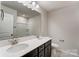 Bathroom with double vanity, mirror, and shower/tub combo at 14926 Tamarack Dr, Charlotte, NC 28278