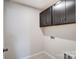 Bright laundry room featuring dark brown cabinets and built-in shelving at 14926 Tamarack Dr, Charlotte, NC 28278