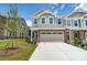 Tan two-story townhome with stone accents and a two-car garage at 14930 Tamarack Dr, Charlotte, NC 28278