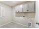 Laundry room with upper cabinets and tile flooring at 14930 Tamarack Dr, Charlotte, NC 28278