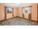 Bedroom with peach walls, wall-to-wall carpet, and two windows with curtains at 3607 Hickory Hwy, Statesville, NC 28677