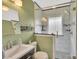 Updated bathroom featuring a tiled shower with glass door, modern vanity, and fresh green paint at 549 Dairy Rd, Troy, NC 27371