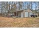 Outbuilding with two roll-up doors, a metal roof, and plenty of outdoor storage at 549 Dairy Rd, Troy, NC 27371