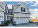 Front view of two-story townhome with white siding and a two-car garage at 7025 Old Evergreen Pkwy, Indian Trail, NC 28079