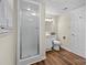 Bathroom featuring a glass enclosed shower, white vanity, and wood-look flooring at 7401 Kilcullen Dr, Charlotte, NC 28270