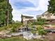 Serene pond with waterfall, stonework, lush greenery, and a historic water wheel at 1000 Lily Pond Cir, Waxhaw, NC 28173