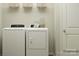 Bright laundry room with washer, dryer, and overhead shelving at 1078 Old Trade St, Edgemoor, SC 29712