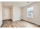 A small bedroom with neutral walls, wood-look flooring, and a view to the front yard at 1187 Blackburn Cir, Edgemoor, SC 29712