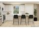 White kitchen with an island and three black barstools at 1187 Blackburn Cir, Edgemoor, SC 29712