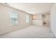 Large carpeted room with natural light from two windows and a large open space for recreation or relaxation at 1189 Blackburn Cir, Edgemoor, SC 29712