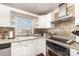 Well-lit kitchen with stainless steel appliances, granite countertops, and unique backsplash at 1209 Austin Chaney Rd, Wingate, NC 28174