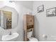 Bright bathroom with a toilet, vanity with large mirror and a wooden storage cabinet at 1219 Century Dr, Clover, SC 29710