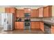 Close-up of a kitchen with stainless steel appliances, wood cabinets, and dark countertops at 1219 Century Dr, Clover, SC 29710