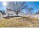 Large backyard with a sloped lawn and a tree at 1309 Winding Branch Ct, Charlotte, NC 28216