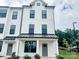 Charming three-story townhouse with a modern farmhouse-style exterior and a gray front door at 15306 Ballancroft Pkwy # 21, Charlotte, NC 28277