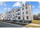 Row of three story townhouses with white siding, gray stairs and landscaping at 15306 Ballancroft Pkwy # 21, Charlotte, NC 28277