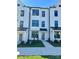 Modern townhome showcases sleek white facade, dark window trim, and well-manicured lawn at 15310 Ballancroft Pkwy # 20, Charlotte, NC 28277