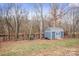 Landscaped backyard with shed, privacy fence, and trees at 1544 Farmington Hills Dr, Conover, NC 28613