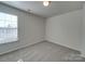 Bright bedroom with gray carpet, window, and double closet at 156 Elrosa Rd, Mooresville, NC 28115