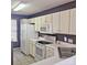 Bright kitchen featuring white cabinets, a microwave, and a corner sink at 16740 Timber Crossing Rd, Charlotte, NC 28213