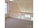 Loft area overlooking the main living space with carpeted flooring at 16740 Timber Crossing Rd, Charlotte, NC 28213