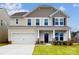 Two-story house with beige and brown siding, a two-car garage, and landscaping at 2125 Clifton Rd, Sherrills Ford, NC 28673