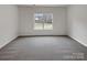 Bright bedroom with grey carpeting and a large window at 2154 Pheasant Glen Rd, Charlotte, NC 28214