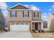 Two-story house with tan siding, brown door, and white garage door at 2262 Redstone Dr, York, SC 29745