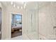 Modern bathroom with a glass shower, marble tile, and city view at 315 Arlington Ave # 2201, Charlotte, NC 28203