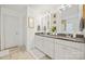 Bright bathroom with double vanity, granite countertops, decorative mirrors, and gold fixtures at 3332 Delaware Dr, Denver, NC 28037