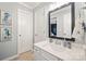 Bathroom featuring white vanity with framed mirror, a large doorway, and neutral-colored tiles at 3332 Delaware Dr, Denver, NC 28037