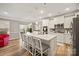 Modern kitchen features white cabinetry, a large center island with bar seating, stainless steel appliances, and wood floors at 3332 Delaware Dr, Denver, NC 28037